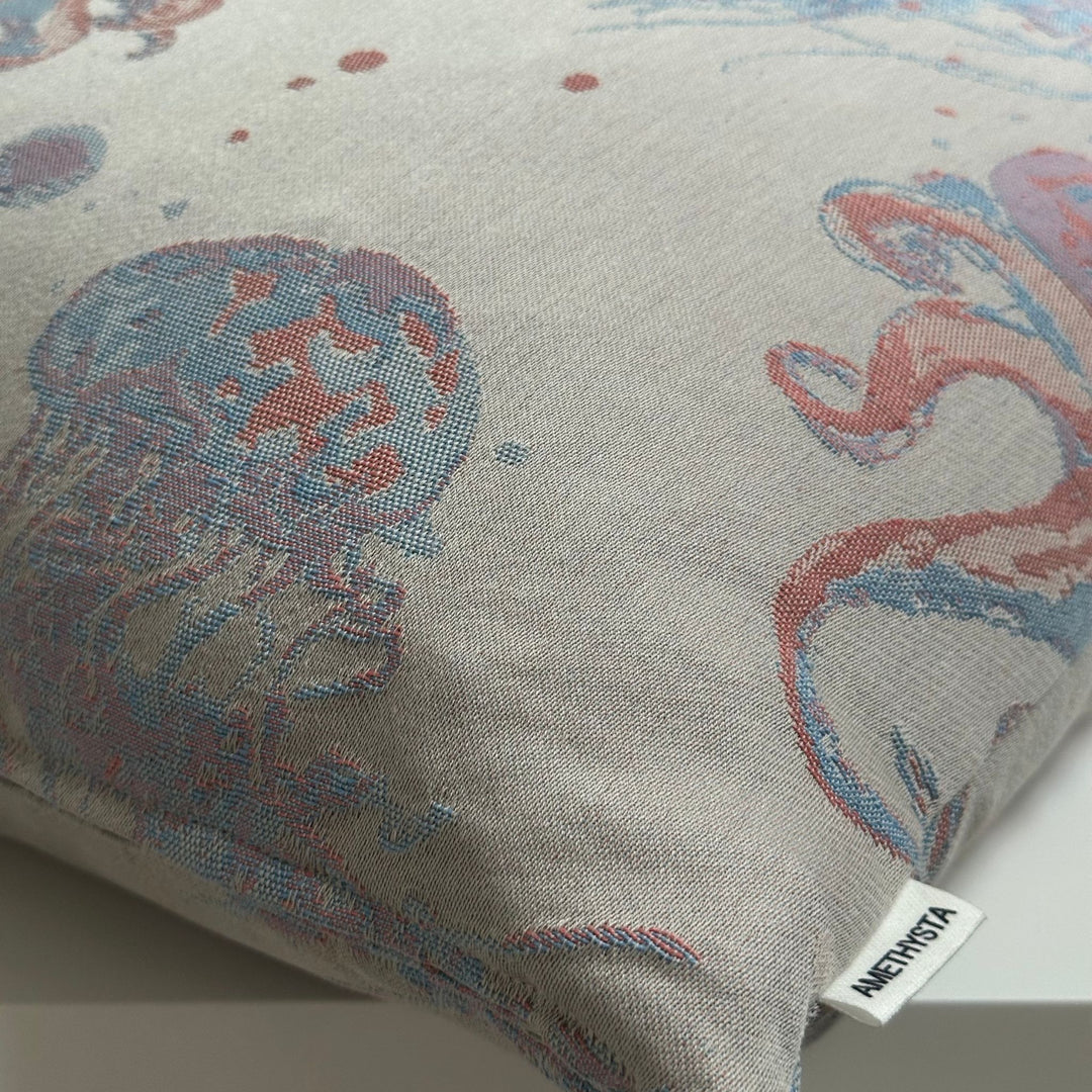Kissen mit Meeresdesign in ruhigen Blau- und Beigetönen, dekorativ auf Sofa mit minimalistischer Deko platziert